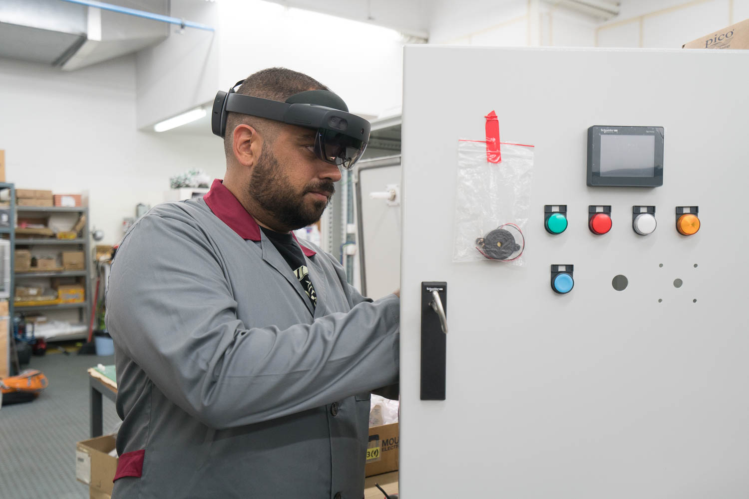 Manufacturing male worker is working on an open electric panel