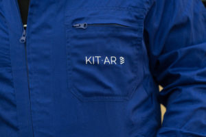 Blue jumpsuit with KIT-AR's logo on top of the left size of the chest