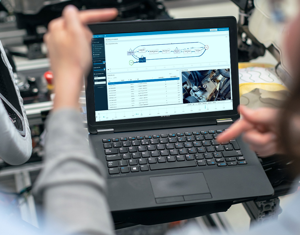 A person holds an open laptop that displays KIT-AR’s platform, that gathers data from the production lines