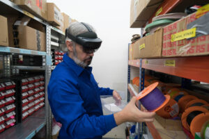 Male worker holds a tape object in a kitting assembly