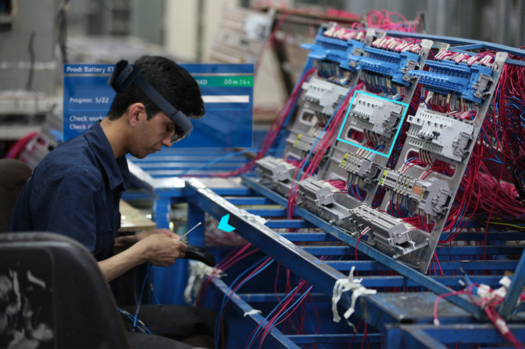 Manufacturing shopfloor worker looks at small piece through extended reality (XR) elements